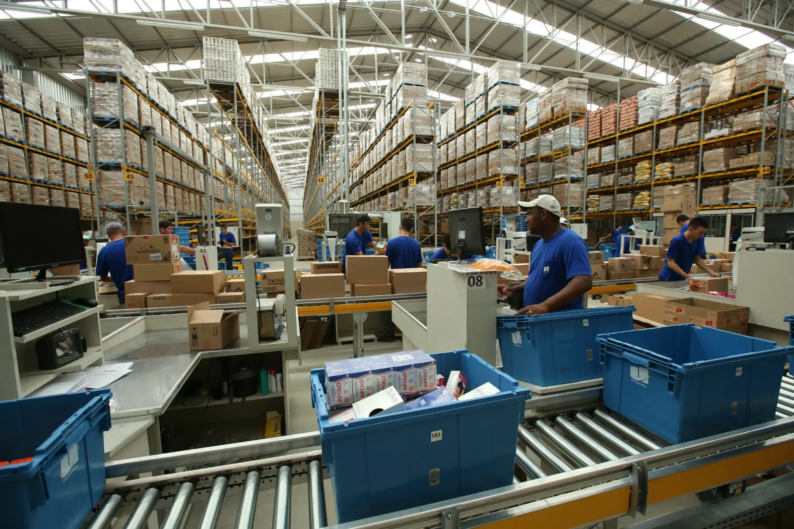 Salão de separação visto do alto, com esteiras e caixas azuis